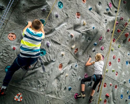 2 Kinder klettern an der Kletterwand