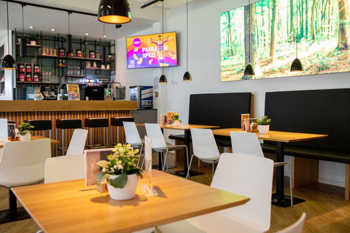 Bistroansicht mit Tischen, Stühlen und Bänken