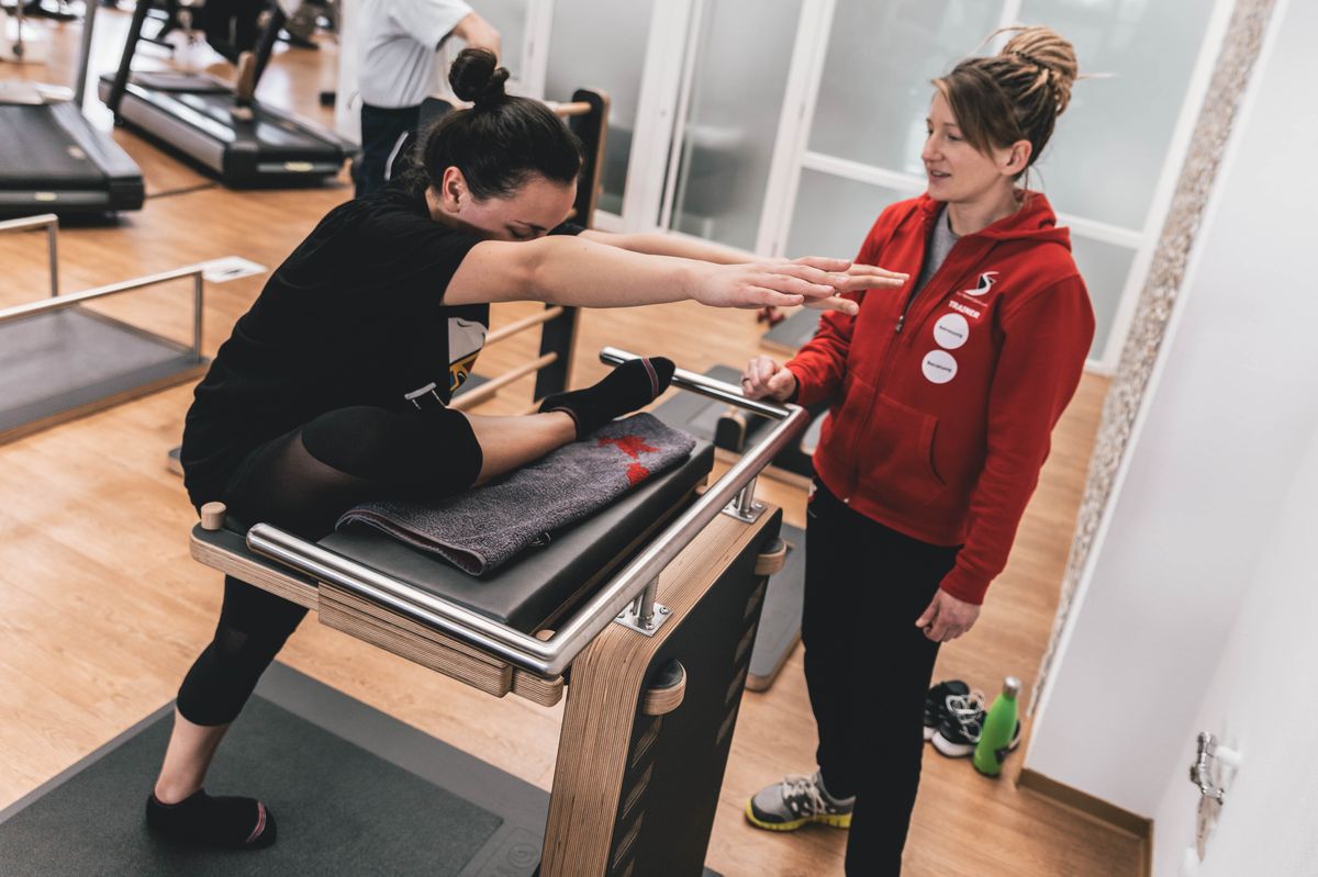 Five Rückenzentrum in Kornwestheim: Trainerin betreut Mitglied an Five Gerät
