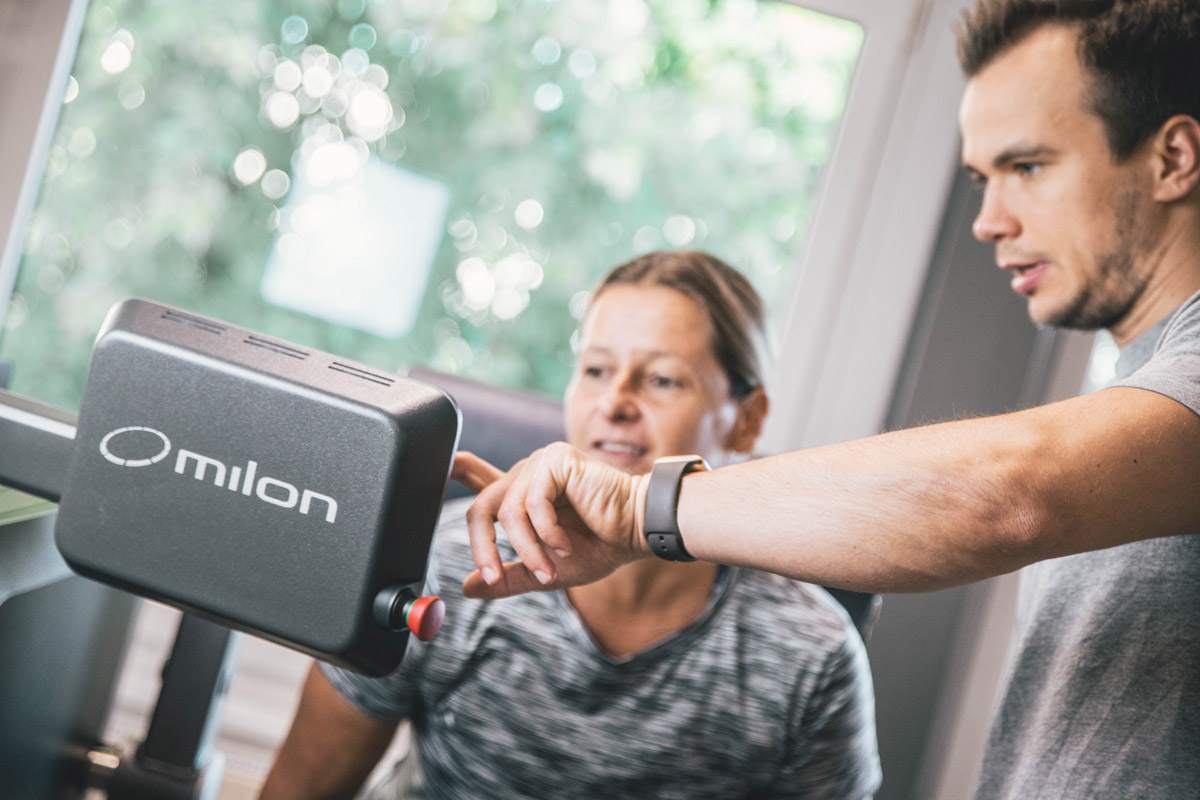 Milon Zirkel in Kornwestheim: Trainer zeigt Mitglied Einstellungen am Gerät