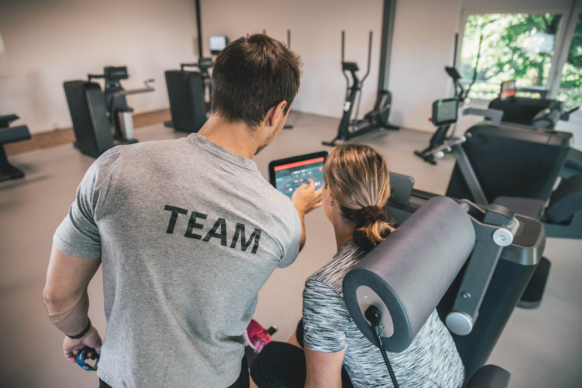 Milon Zirkel in Kornwestheim: Trainer zeigt Mitglied Einstellungen am Gerät