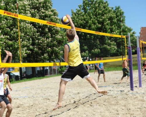 Beachvolleyball: Spieler schmettert den Ball über das Netz