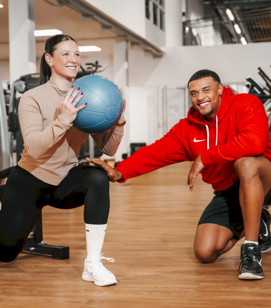 Dein Wohlfühl Fitnessstudio in Kornwestheim -Trainer betreut Mitglied bei Ausfallschritt