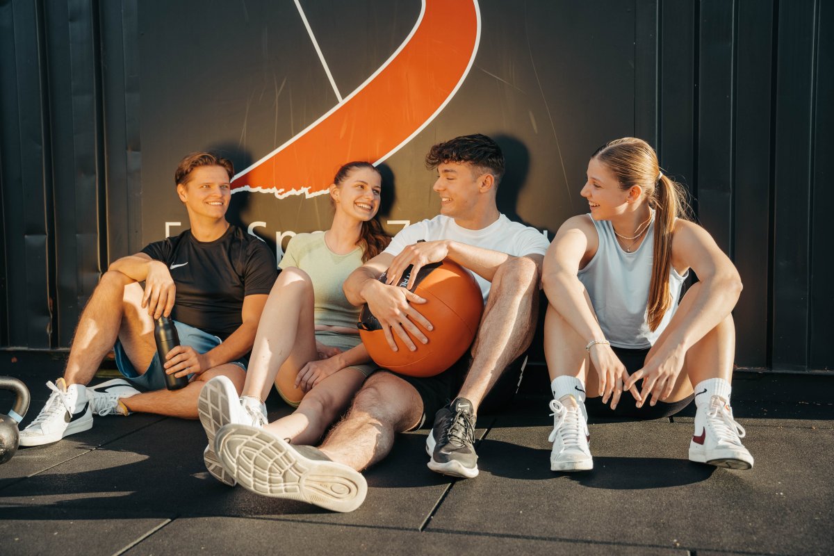 Freunde sitzend am Container im Outdoor Fitnesspark im FunSportzentrum